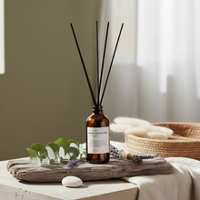 Of The Sea Reed Diffuser with eucalyptus lavender peppermint essential oils - amber glass bottle with rattan reeds on natural linen surface